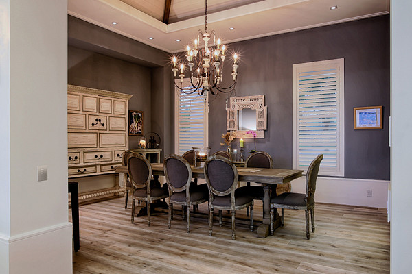 A dining room with an exposed Palladiom roller shade, its machined brackets meant to be seen.