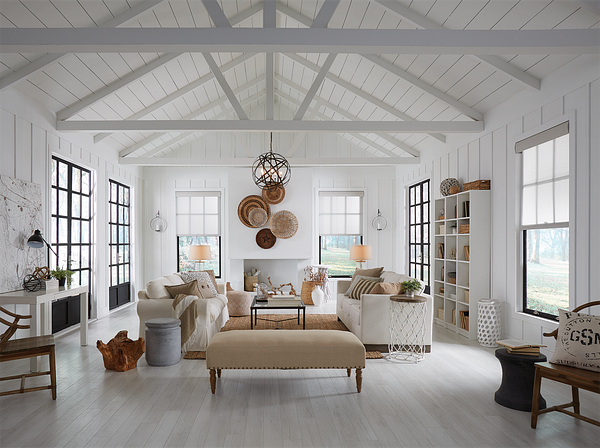A white farmhouse living room under an open truss ceiling, with roller shades and wall sconces, no recessed downlights in sight.